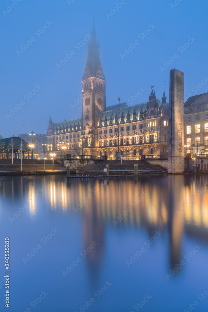 The City Hall (Rathaus) of Hamburg, Germany, in the fog at dusk. The City Hall (Rathaus) of Hamburg, Germany, in the fog at dusk.