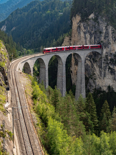 Red train on famous Landwasser Viaduct bridge.The Rhaetian Railway section from the Albula/Bernina area (the part from Thusis to Tirano, including St Moritz), Switzerland, Europe. August, 2018 photo