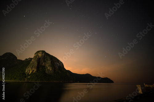 Night landscape with dark silhouettes of mountains and sky with stars 