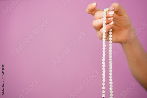 Bild auf Leinwand Woman, lit hand close up, counts Malas, strands of gemstones beads used for keep