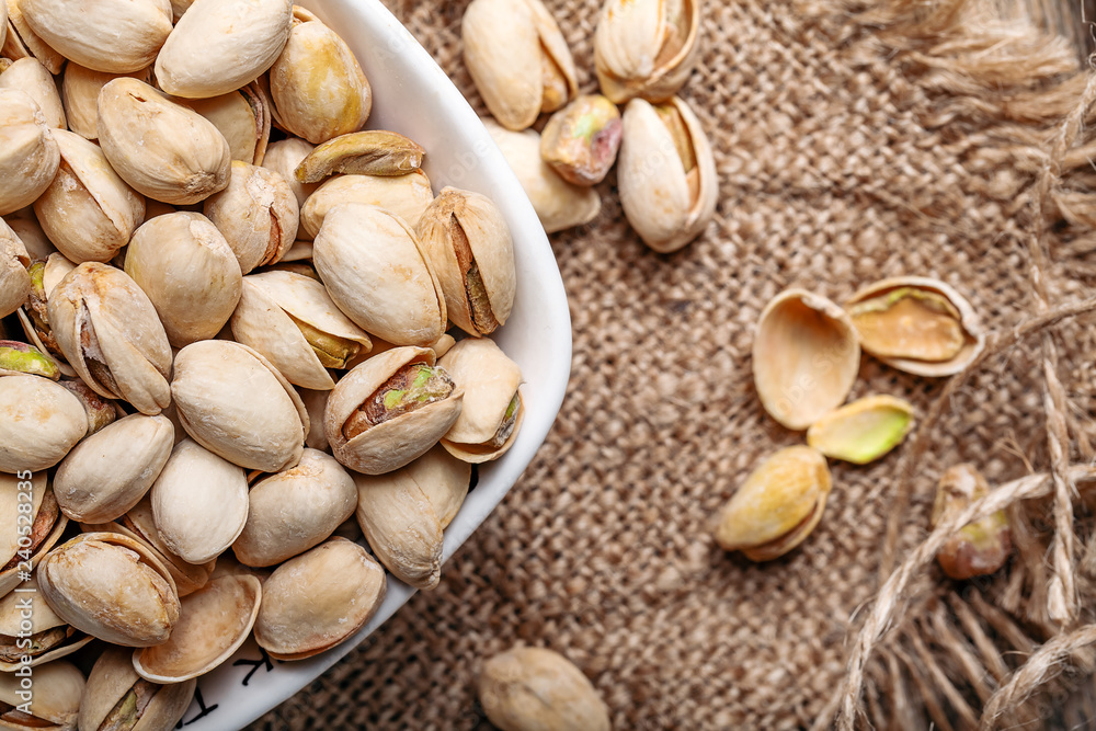 Some whole Pistachios (selective focus; close-up shot) on wooden background top view Some whole Pistachios (selective focus; close-up shot) on wooden background top view