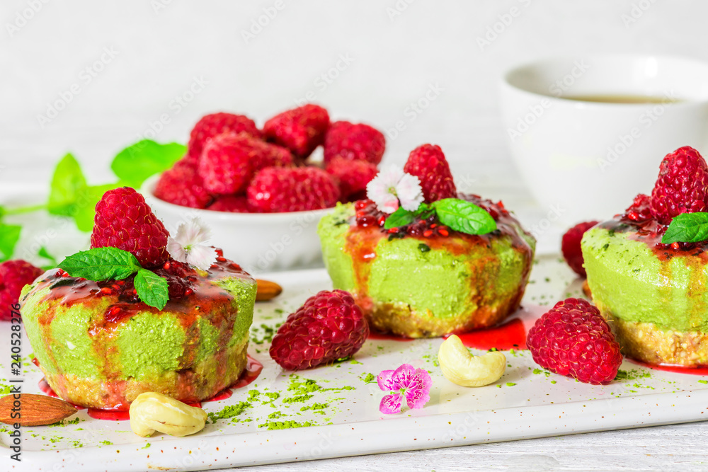 matcha green tea vegan raw cheesecakes with raspberries, mint, nuts and flowers. healthy delicious food