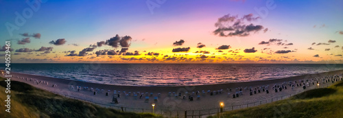The beach of Westerland on the island of Sylt, Germany. Panoramic view at sundown with spectacular evening sky colors. photo