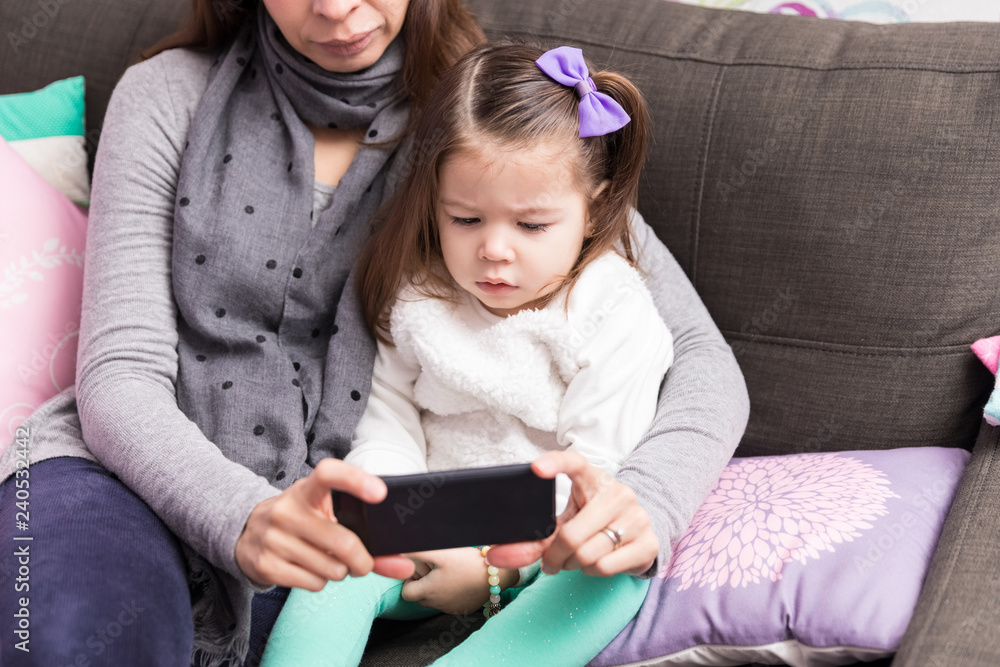 Mother And Daughter Using Mobile Phone On Sofa Mother And Daughter Using Mobile Phone On Sofa