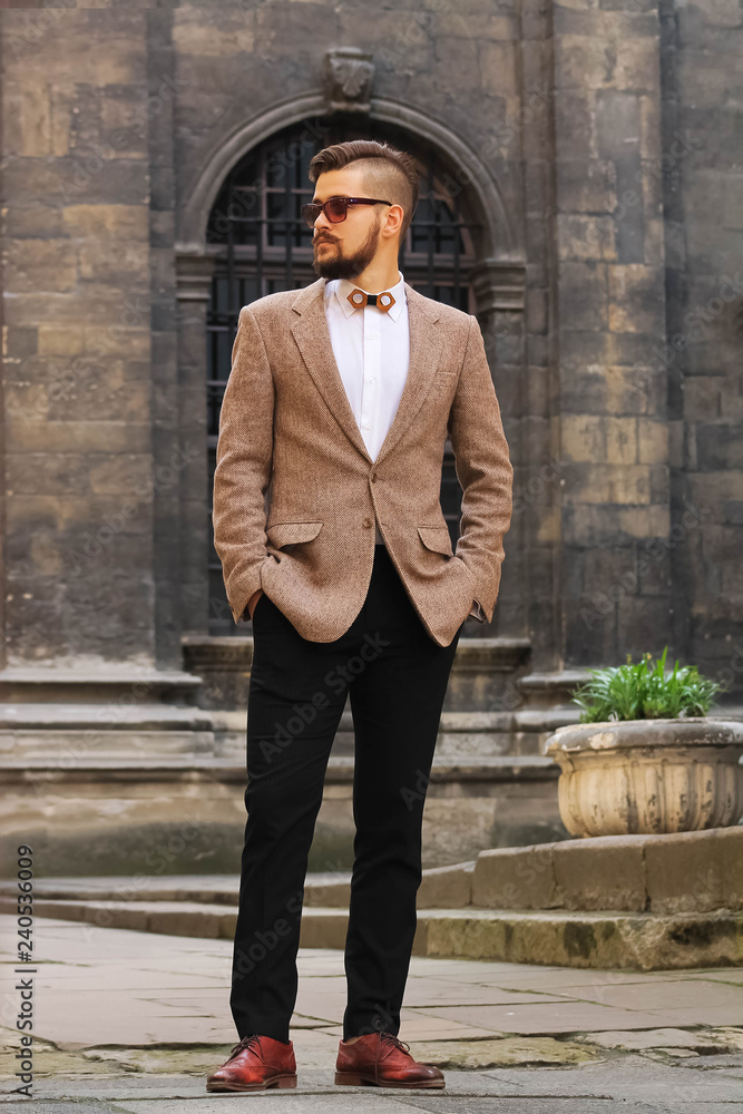 Genoptag Retningslinier Spiller skak Young confident hipster man with beard in glasses posing on the street in  old town. Attractive man wearing a suit, white shirt and light trousers.  Stock Photo | Adobe Stock