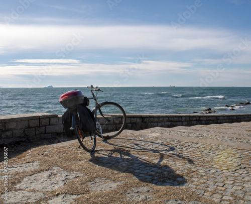 Bicycle on the background of the sea and sky with clouds
