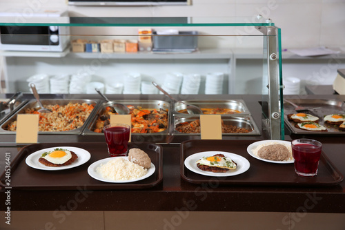 Trays with healthy food on serving line in school canteen