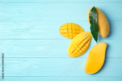 Flat lay composition with mango on wooden background. Space for text