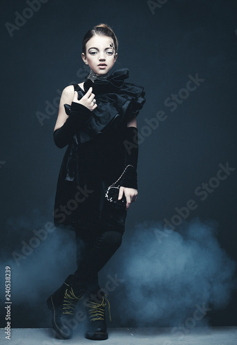 Beauty and fashion concept: Little girl wearing black outfit. Creative make up.