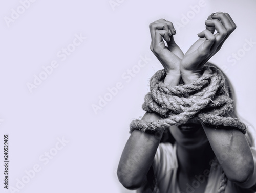  Concept of gender discrimination against women.  Hands tied up with rope of woman. Black and white portrait photo.