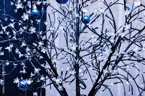 Wire woven artificial tree with little flowers lamps and hanging blue chrismass tree glass balls photo