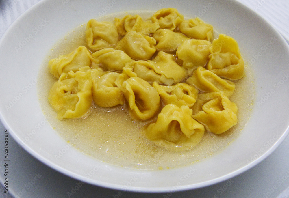 Tortellini in brodo (in broth) in a white plate, italian emilia-romagna pasta Tortellini in brodo (in broth) in a white plate, italian emilia-romagna pasta