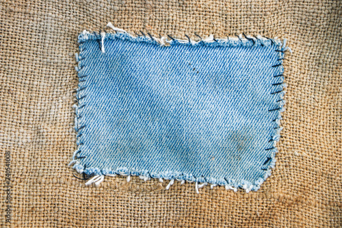 Blue jeans patch on an old canvas bag. Close-up.