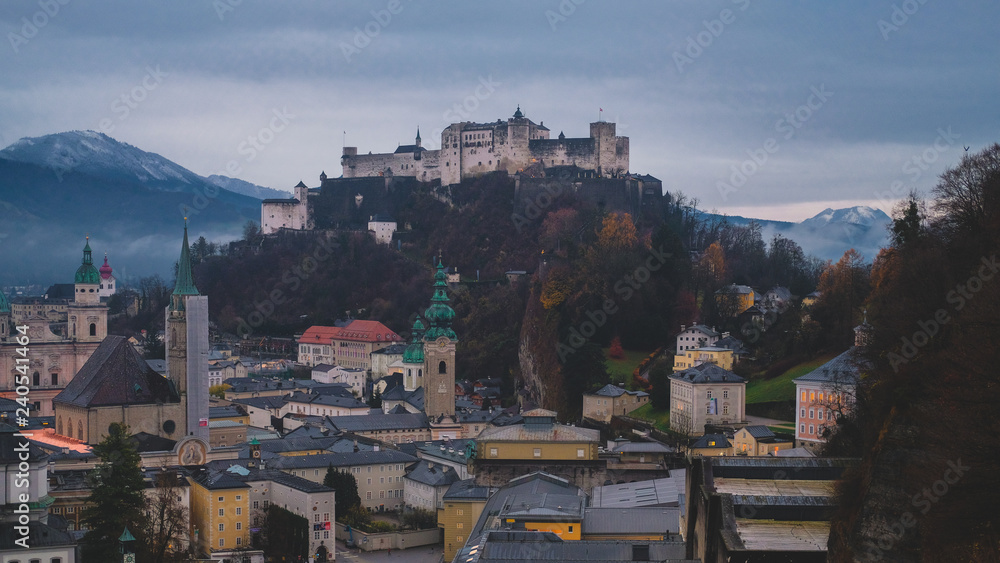 Fototapeta premium Castle and fortress Hohensalzburg on mountain Festung in Salzburg city, Austria. Moody dark cityscape late autumn.
