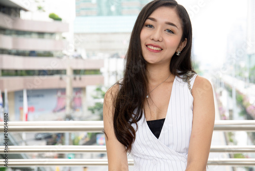Beautiful Asia woman smile portrait on walking street in the city. Free Download Beautiful Asia woman smile portrait on walking street in the city. - GFXLoad