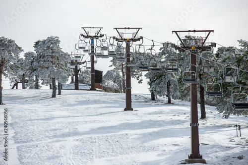 Snowy mountain in ski resort in early European winter. Snow ridge with ski and snowboard cable car ready to receive tourists who like cold on sunny days