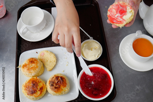 Фотография Young muslim woman sweep the strawberry jam on scone at the strawberry farm at Cameron Highland