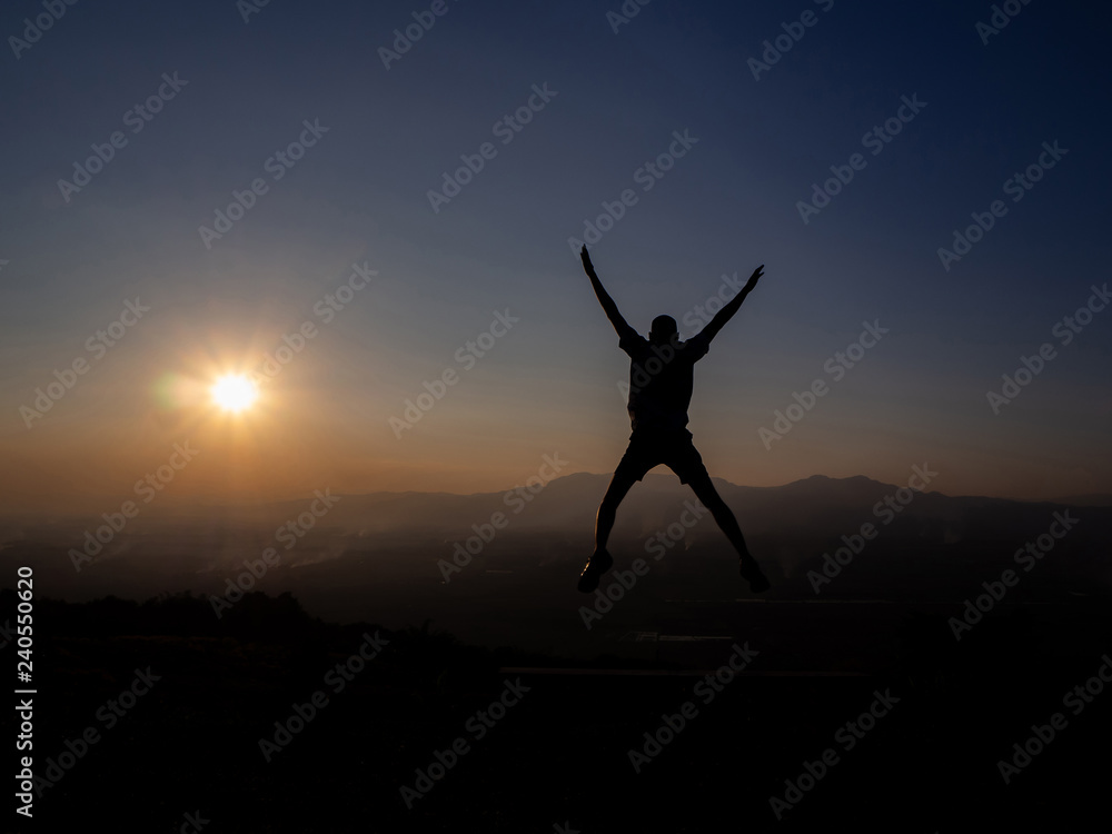 Young man jump in the form of a silhouette in the sunset.
