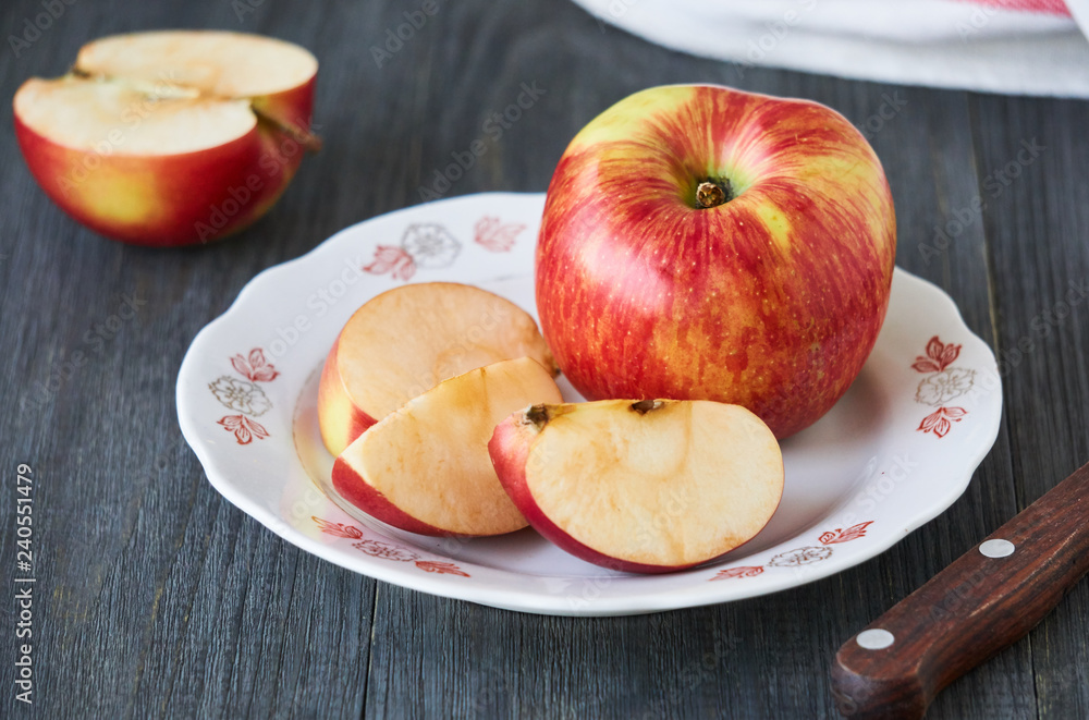 Slices of ripe red apple on a white plate Slices of ripe red apple on a white plate