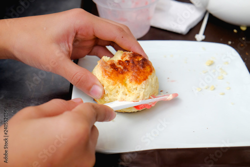Фотография Young muslim woman sweep the strawberry jam on scone at the strawberry farm at Cameron Highland