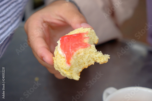 Фотография Young muslim woman eating delicious scone with strawberry jam and tea at the strawberry farm at Cameron Highland