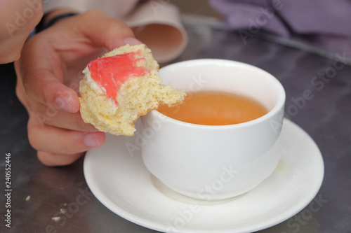 Фотография Young muslim woman eating delicious scone with strawberry jam and tea at the strawberry farm at Cameron Highland