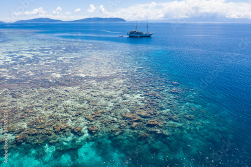 Aerial of Beautiful Coral Reef and Traditional Ship in Raja Ampat