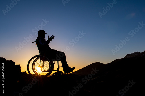man in wheelchair watching amazing sunrise
