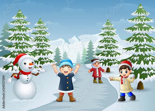 Happy kids playing with a snowman in winter