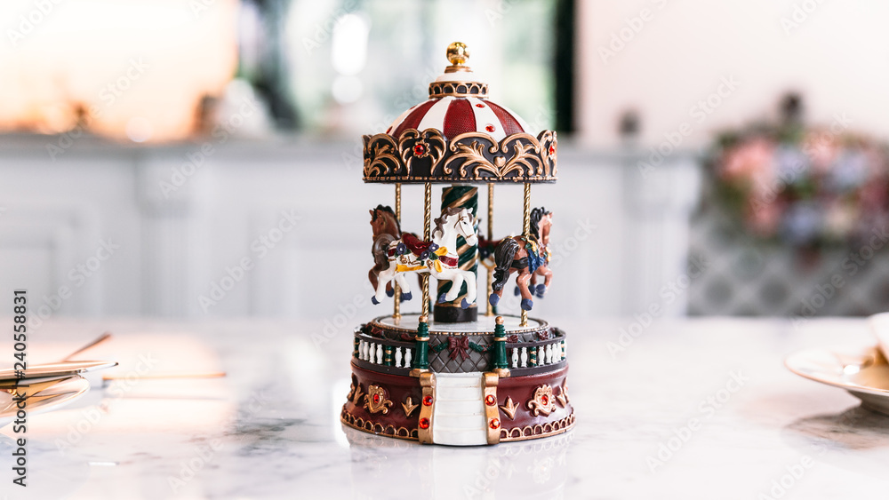 Miniature Carousel Toy over white marble top table with blur background ...