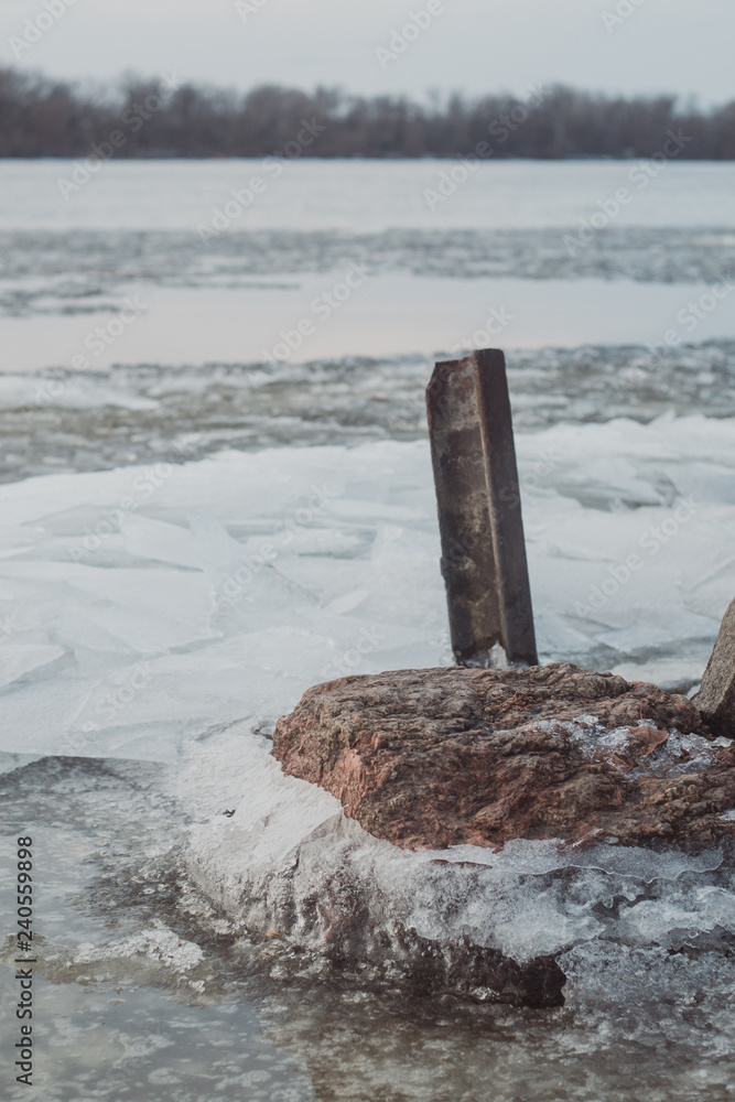 Fototapeta premium Evening on the river bank. Evening on the riverside. The frozen stones in the river coast. 