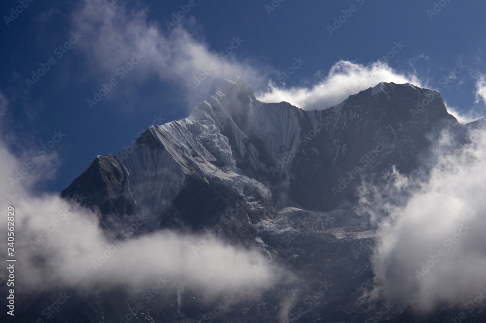 Snowy peaks in the clouds. Trekking to Annapurna Base Camp