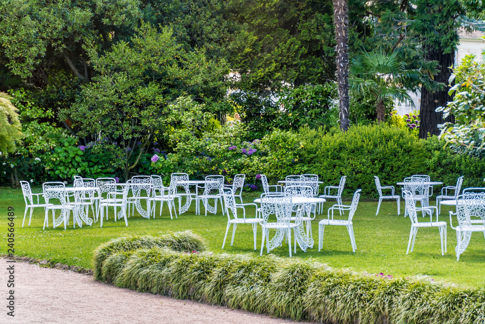 White Metal Chairs and Tables in Outdoor Luxury Italian Restaurant White Metal Chairs and Tables in Outdoor Luxury Italian Restaurant