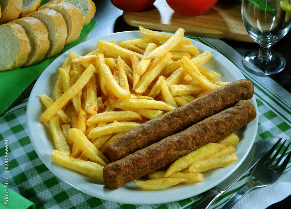 Plato combinado de dos salchichas de tipo aleman y patatas fritas. Plato combinado de dos salchichas de tipo aleman y patatas fritas.