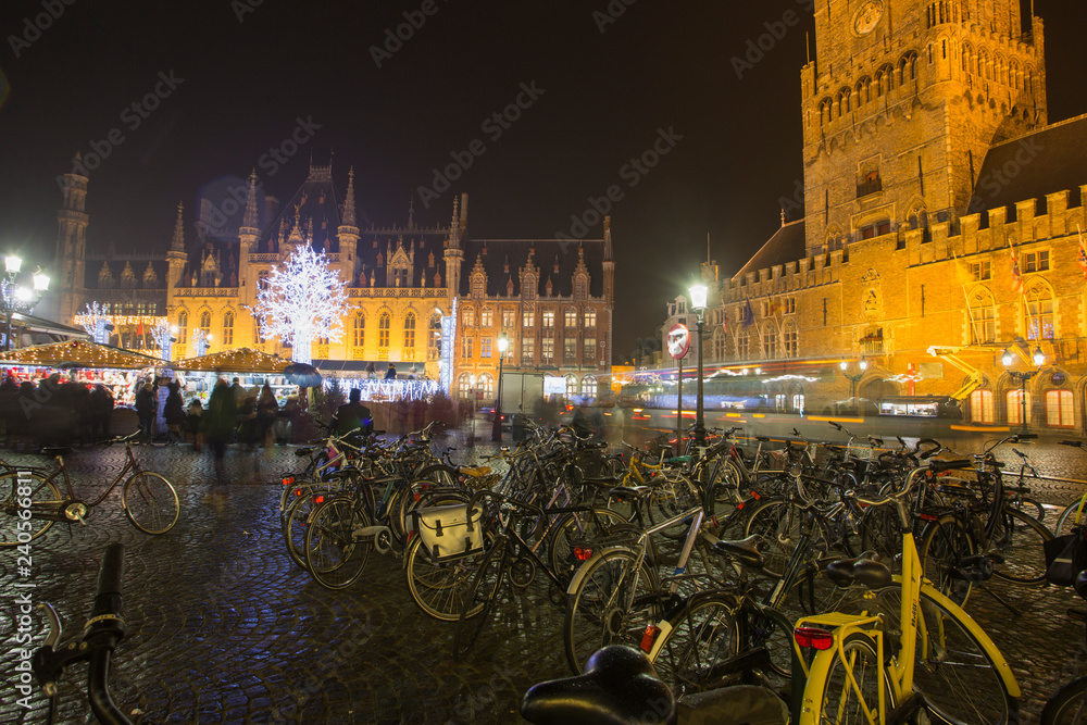 Bruges, Belgium - November 24, 2018: Central Bruges Market Square by night decorated at Christmas.