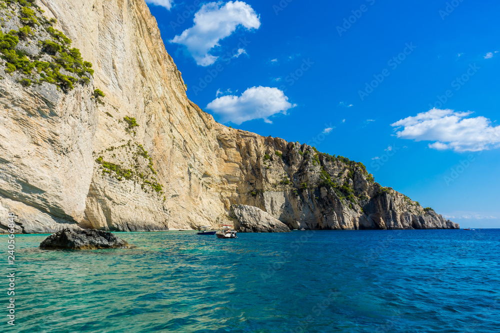 Greece, Zakynthos, Tour boats in perfect azure waters next to impressive chalk cliffs
