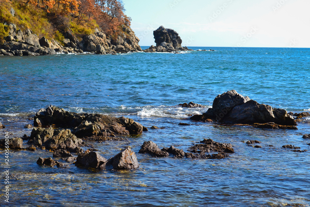 rocky seashore, water splashing on rocks in the sea