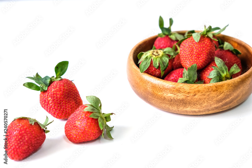 Fresh juicy strawberries with leaves placed on a white table Fresh juicy strawberries with leaves placed on a white table