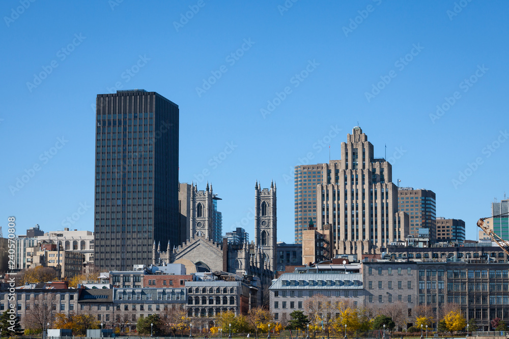 Skyline of the Old Montreal, with the Notre Dame Basilica in front, and stone and glass Skyscrapers in the background. The basilica is the main cathedral of Montreal, Quebec, Canada, and a landmark