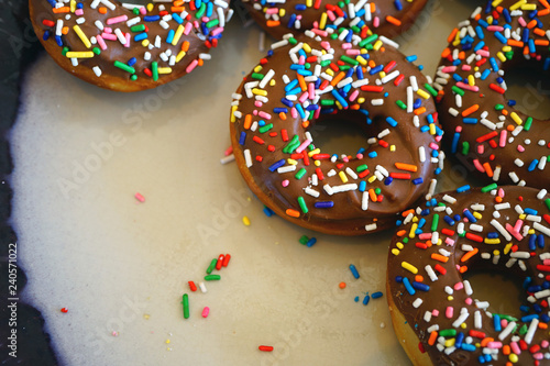 Fresh donuts with chocolate icing and colorful sprinkles