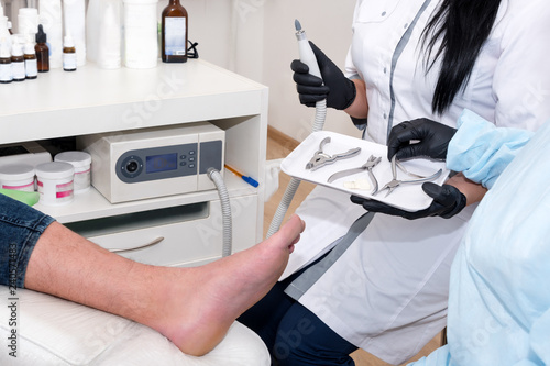 Podology treatment. Podiatrist treats foot. Podiatry doctor or dermatologist treats the patient in modern clinic photo