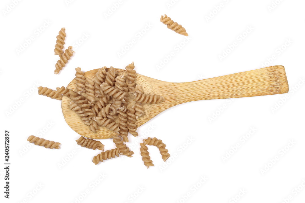 Obraz premium Wholemeal pasta with wooden spoon isolated on white background, top view