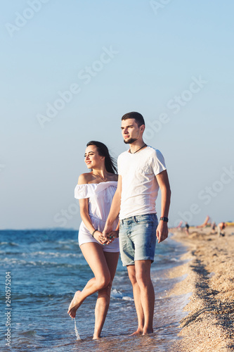 Young happy couple posing by the sea. © Marina Varnava