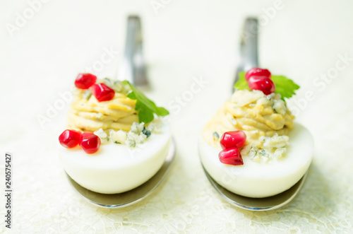 Blue cheese deviled eggs with pomegranate and fresh parsley leaves