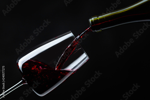 Red wine being poured into wineglass.