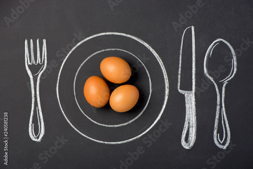 Boiled chicken eggs on a plate in the figure on a chalk board
