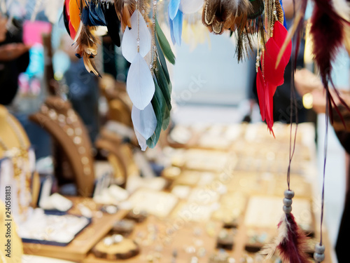 Beautiful colored ornamental feather with blur shop background in christmas market.