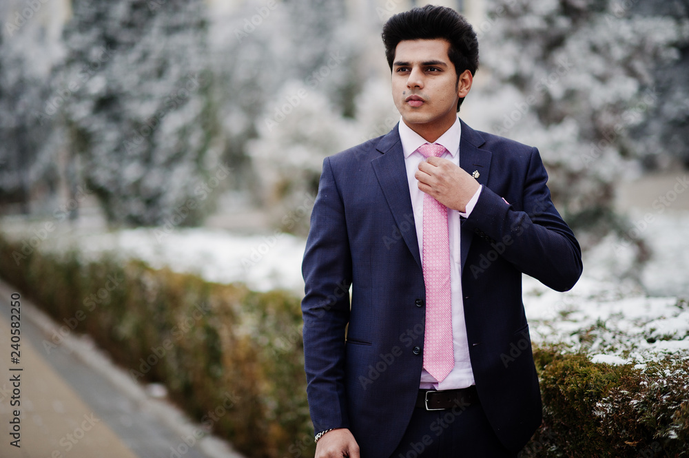 Elegant indian macho man model on suit and pink tie posed on winter day. Elegant indian macho man model on suit and pink tie posed on winter day.