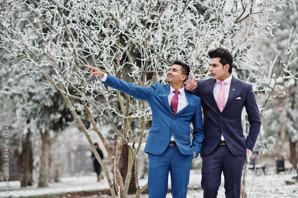 Two elegant indian fashionable mans model on suit posed at winter day, show something. Two elegant indian fashionable mans model on suit posed at winter day, show something.