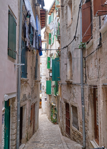 Street view in the old historic 19th century town of Rovinj Croatia.  Cobbledstone pavement, houses, and hanging laundry all part of scenery